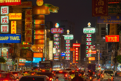 Night market street at Yaowarat road, Bangkok City, Thailand. The famous tourist attraction with full of advertising Chinese signs. Cars of tourists people with billboard. China town.