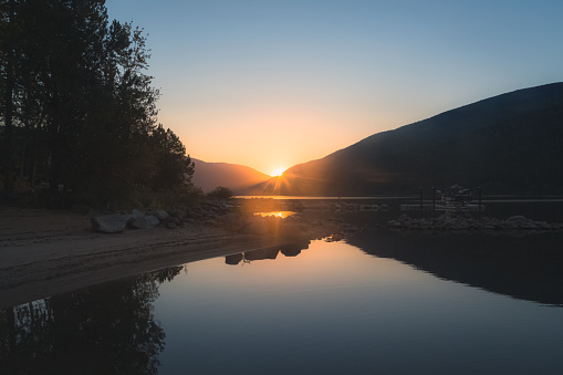 A beautiful, calm, idyllic summer sunset or sunrise on Kootenay Lake in Nelson, British Columbia, Canada