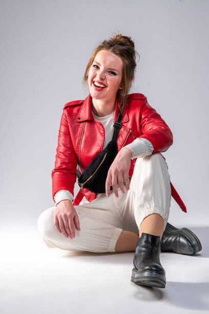 istock Cute woman in red leather jacket on gray background. 1317319410