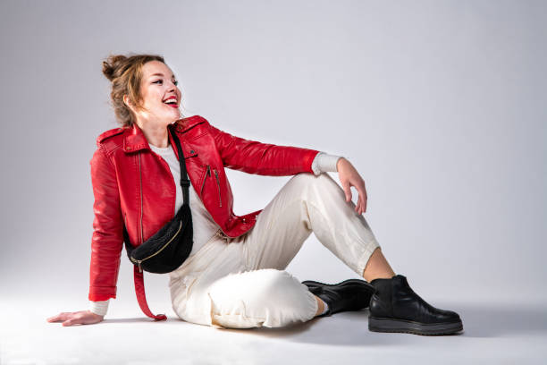 istock Cute woman in red leather jacket on gray background. 1317319461