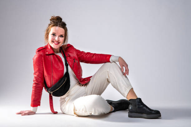 istock Cute woman in red leather jacket on gray background. 1317319466