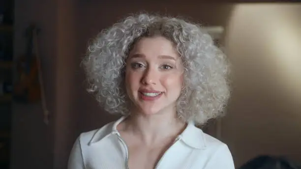 Portrait of happy cute woman with curly white-hair.