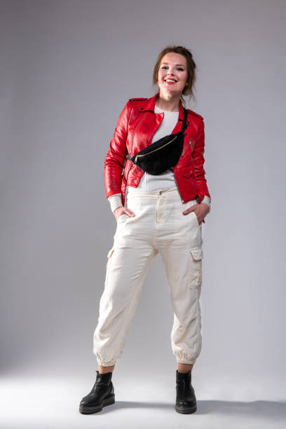istock Cute woman in red leather jacket, smiling, posing on gray background. 1317323888