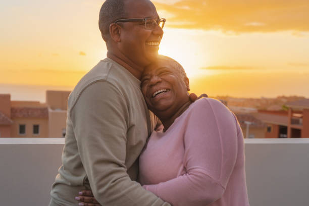 glückliches lateinisches senior-paar mit romantischem moment umarmt auf dem dach bei sonnenuntergang - ältere menschen lieben konzept - latin american and hispanic ethnicity senior adult mature adult couple stock-fotos und bilder