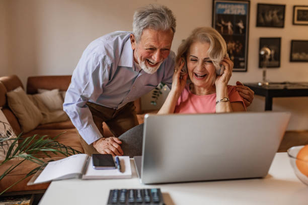 istock Senior couple at home, using laptop together 1317329514