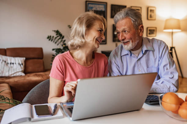 istock Senior couple at home, using laptop together 1317330401