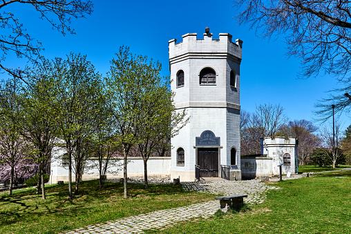 New York, NY - April 6, 2021: This castle with a two-story tower encloses the Connie Gretz Secret Garden, at Sailor's Snug Harbor in Staten Island, NYC. The garden contains a shrubbery maze with greenery, flowers, and benches.