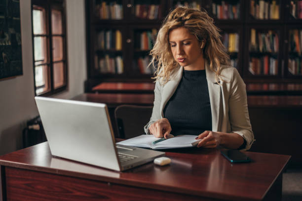 istock Businesswoman using a laptop and business planner while working in an office 1317337158