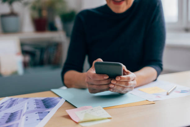 istock Unrecognizable Businesswoman Using her Mobile Phone at Work 1317338662