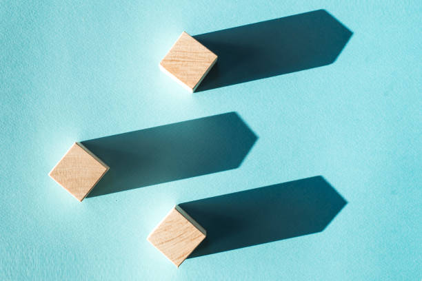 istock Three wooden blocks image with strong lights create deep shadows in a blue background. Concept 1317340038