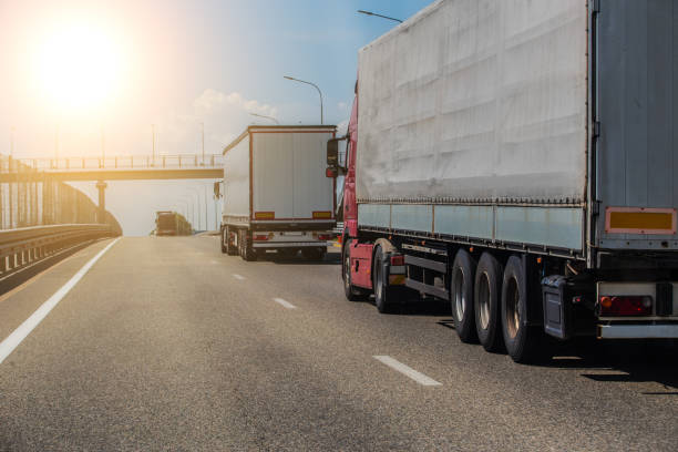 istock Trucks deliver cargo in opposite directions on a suburban highway 1317340337