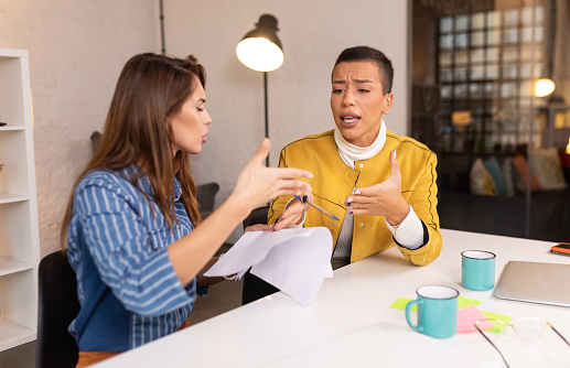 Photo of angry bossy business woman shout at irritated woman at work