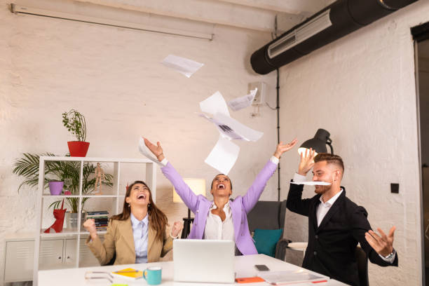 istock Small group of happy people throwing documents in the air 1317344091
