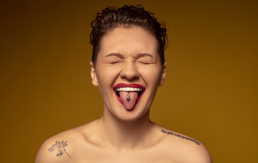 The young woman with a piercing on her tongue closed her eyes and stuck her tongue out.