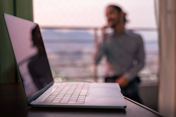 istock Close-up of a computer with a young blurred man at the background 1317345037