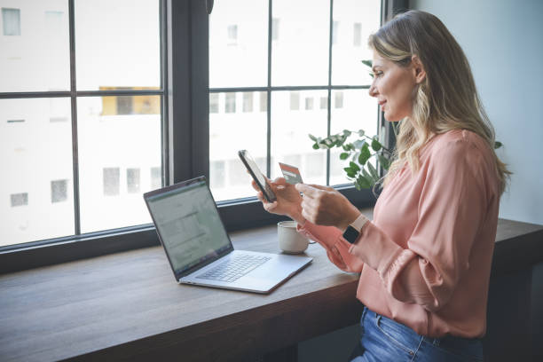 istock attractive middle aged woman working in the office ( Online Shopping smart phone) 1317348025