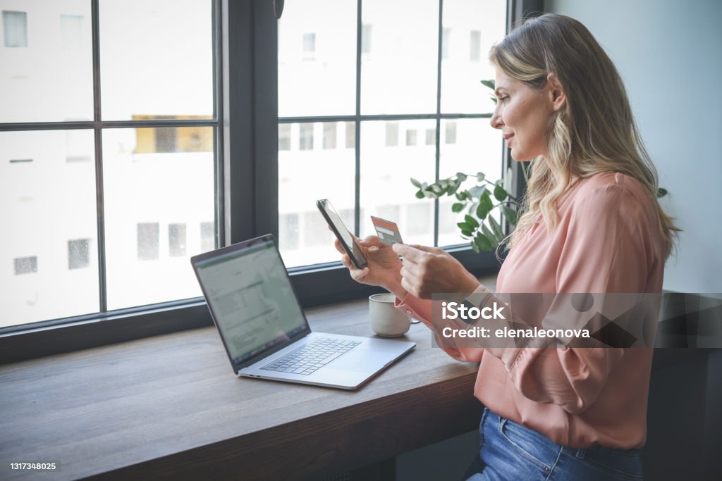 attractive middle aged woman working in the office ( Online Shopping smart phone) attractive middle aged woman working in the office Subscription Stock Photo