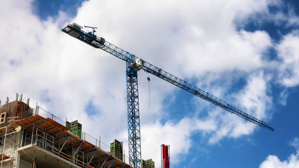 istock Construction crane against a cloudy sky on a sunny May Springtime day 1317355195