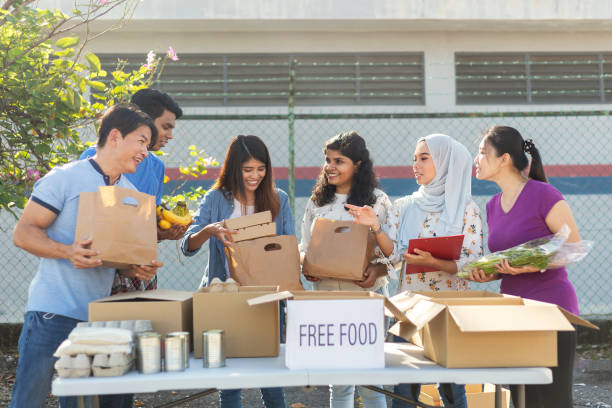 счастливые многоэтнические добровольцы в продовольственном банке готовятся к благотворительной продовольственной диск - food canned food drive motivation стоковые фото и изображения