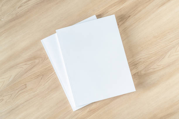 istock Book cover mockup with blank white front paper page a4 paperback mock up for catalog, magazine, menu, booklet, notebook, portfolio design template on wood table background 1317361421