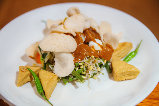 Close up shot Gado-gado ,an Indonesian salad of slightly steamed vegetables and hard-boiled eggs, boiled potato, and fried tofu, served with a peanut sauce dressing.