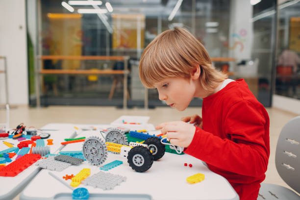 mały chłopiec dziecko konstruktor dziecko sprawdzanie techniczne chyć. robotyka dziecięca montuje robota. - child building activity construction engineer zdjęcia i obrazy z banku zdjęć