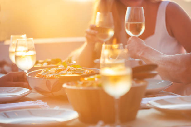 istock Group of unrecognizable people drinking wine outdoors at sunset. 1317362619