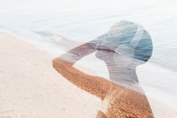 Double exposure shape. Music relaxation. Nature recreation. Portrait silhouette of calm girl enjoying listening wave sound in headphones by sea on faded beach sand water background.