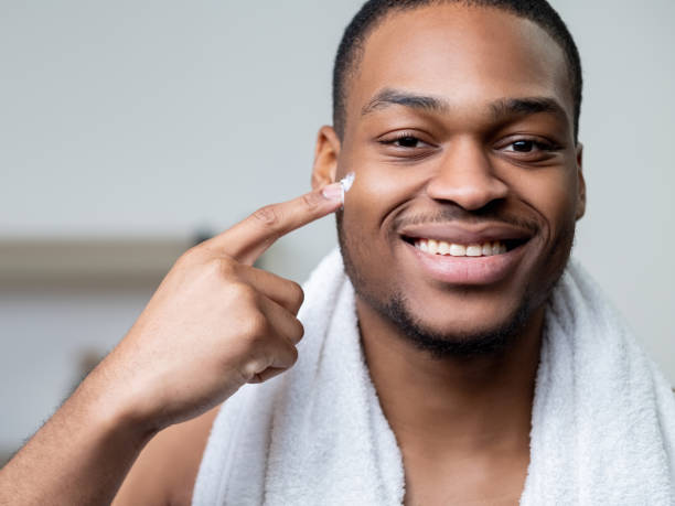 crema masculina para hombre africano para el cuidado de la piel en la piel de la cara oscura - male towel men human face fotografías e imágenes de stock