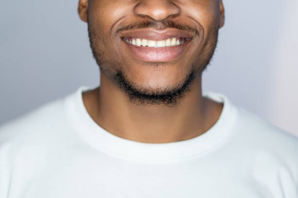 zahnpflege zahnhygiene lächeln afrikanischen mann gesicht - queens head stock-fotos und bilder