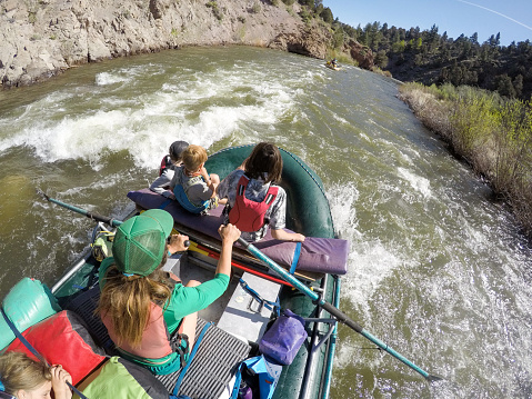 A couple take their children on a white water rafting camping trip in California.