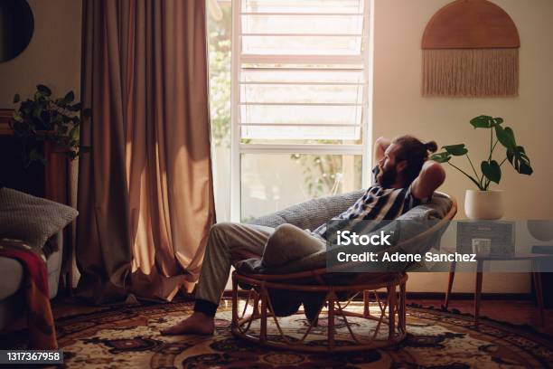 Shot Of A Young Man Relaxing On A Chair At Home Stock Photo - Download Image Now - Relaxation, Men, Domestic Life