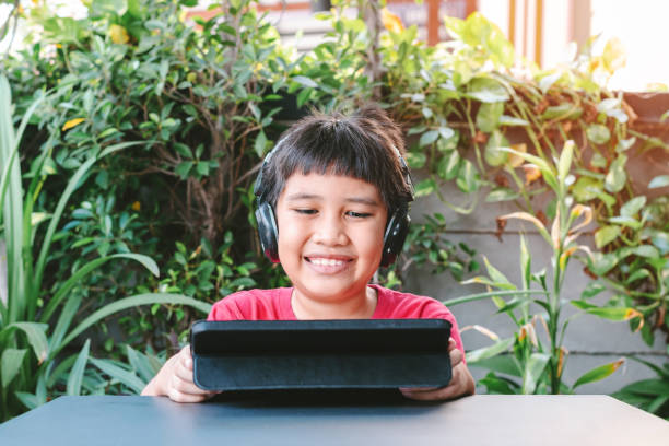 istock Asian cute boy playing games on the tablet. 1317372436