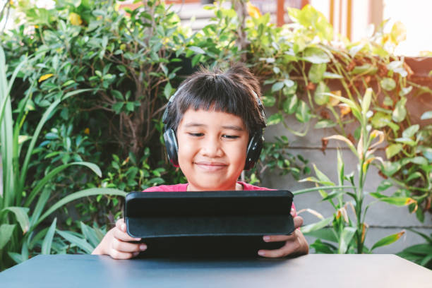 istock Asian cute boy playing games on the tablet. 1317372447