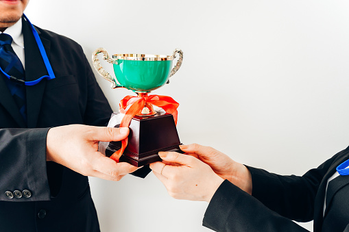 A businesswoman receives a trophy from her boss