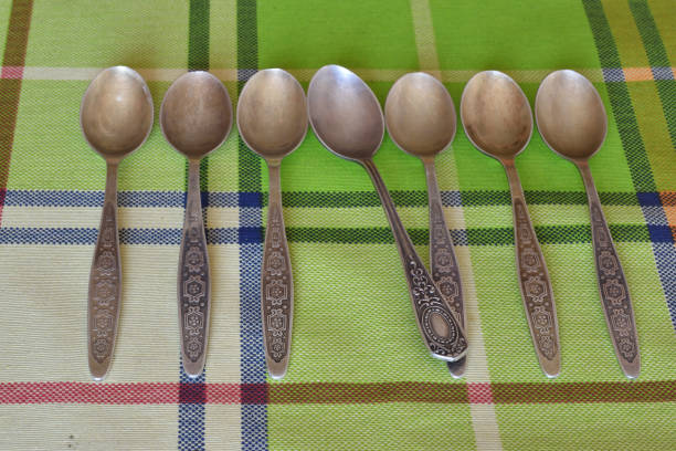 istock A set of silver teaspoons with a spoon from another set. 1317381517