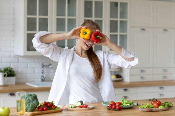 istock Young woman having fun in kitchen while prepares fresh vegetables stay home 1317382334