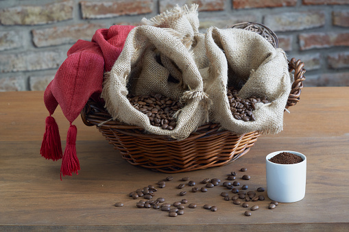 Bolsas de granos de café tostados sobre mesa de madera, predominantemente de color marrón y tostado. photo