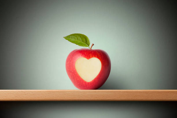 apple con símbolo de corazón en el estante - valentines day teenager passion romance fotografías e imágenes de stock