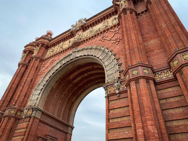 Low angle frontal view the red Arc de Triomf in Barcelona Low angle frontal view the red Arc de Triomf in Barcelona, Spain arc de triomf barcelona stock pictures, royalty-free photos & images