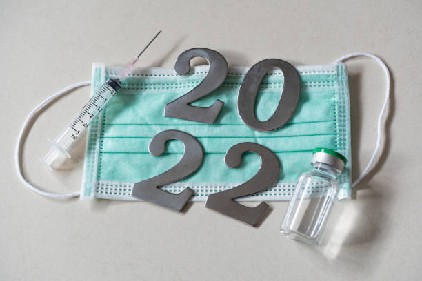 istock 2022 with face mask, syringe and vaccine vial 1317385697