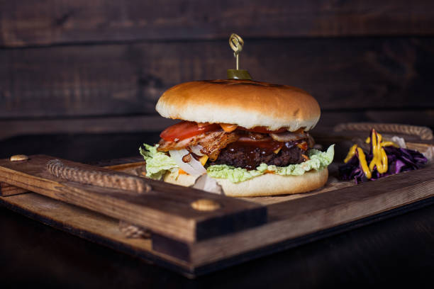 istock cheeseburger on a wooden tray in a restaurant, on a dark background 1317386546