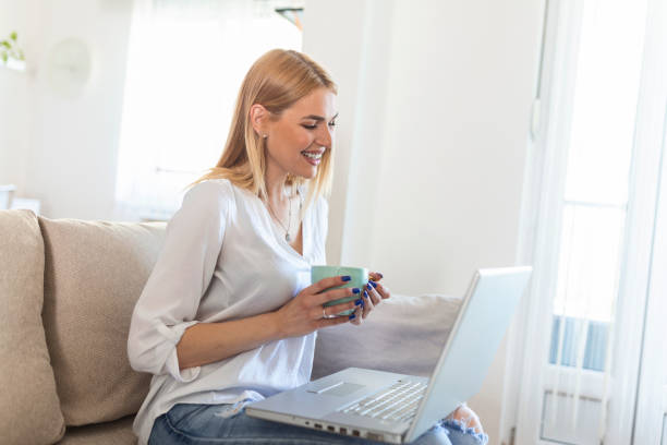 istock Nice beautiful lady with long hair work at the notebook sit down on the sofa at home - check on oline shops for cyber monday sales - technology woman concept for alternative office freelance 1317389547