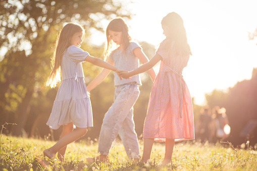 Dancing and be happy. Three little girls together in nature.