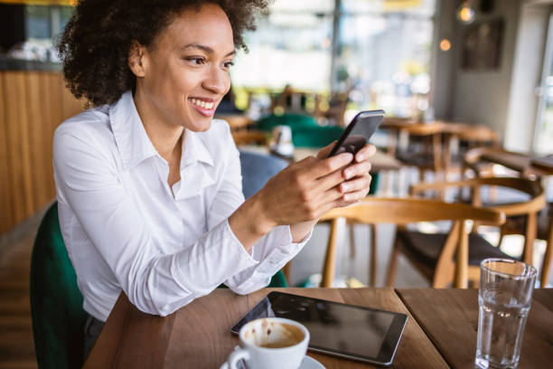 istock Mixed race business woman using phone in a cafe. 1317391031