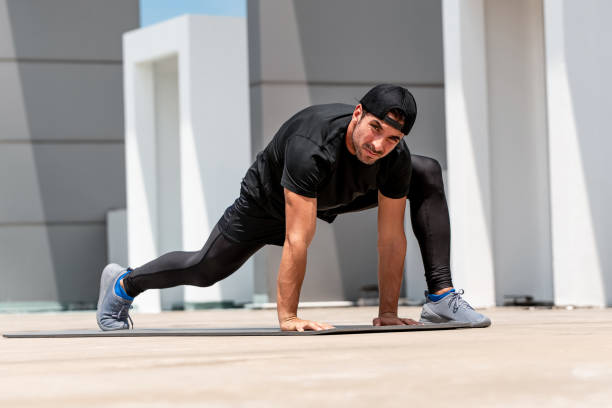 istock Fit handsome sports man warming up with spider lunge exercise outdoors on building rooftop floor 1317391038