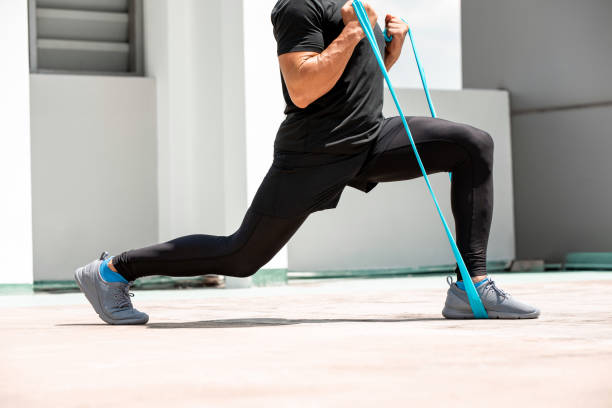 istock Athletic man doing lunge workout exercise with resitance band outdoors on building rooftop in the sun 1317391062
