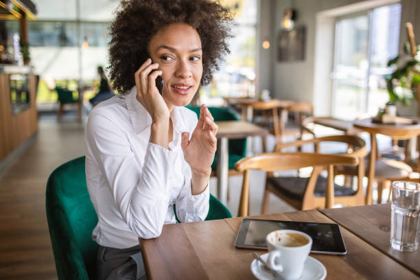 istock Mixed race business woman using phone in a cafe. 1317391082