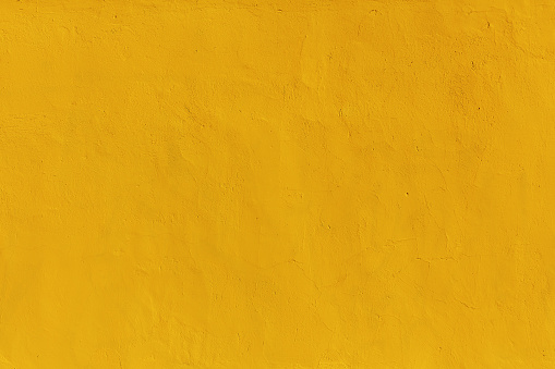 Light yellow uneven plastered wall as a quality classic background for decor and design