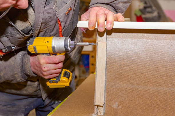 カーペンターは、ハンドドリル、アクク電動工具を使用し、木製のドアフレームのネジを締めます。 - hand drill hand tool screwdriver drill ストックフォトと画像